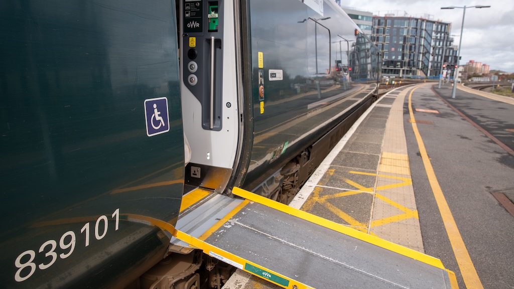train standing in a station with accessibility ramp positioned at accessible door entrance